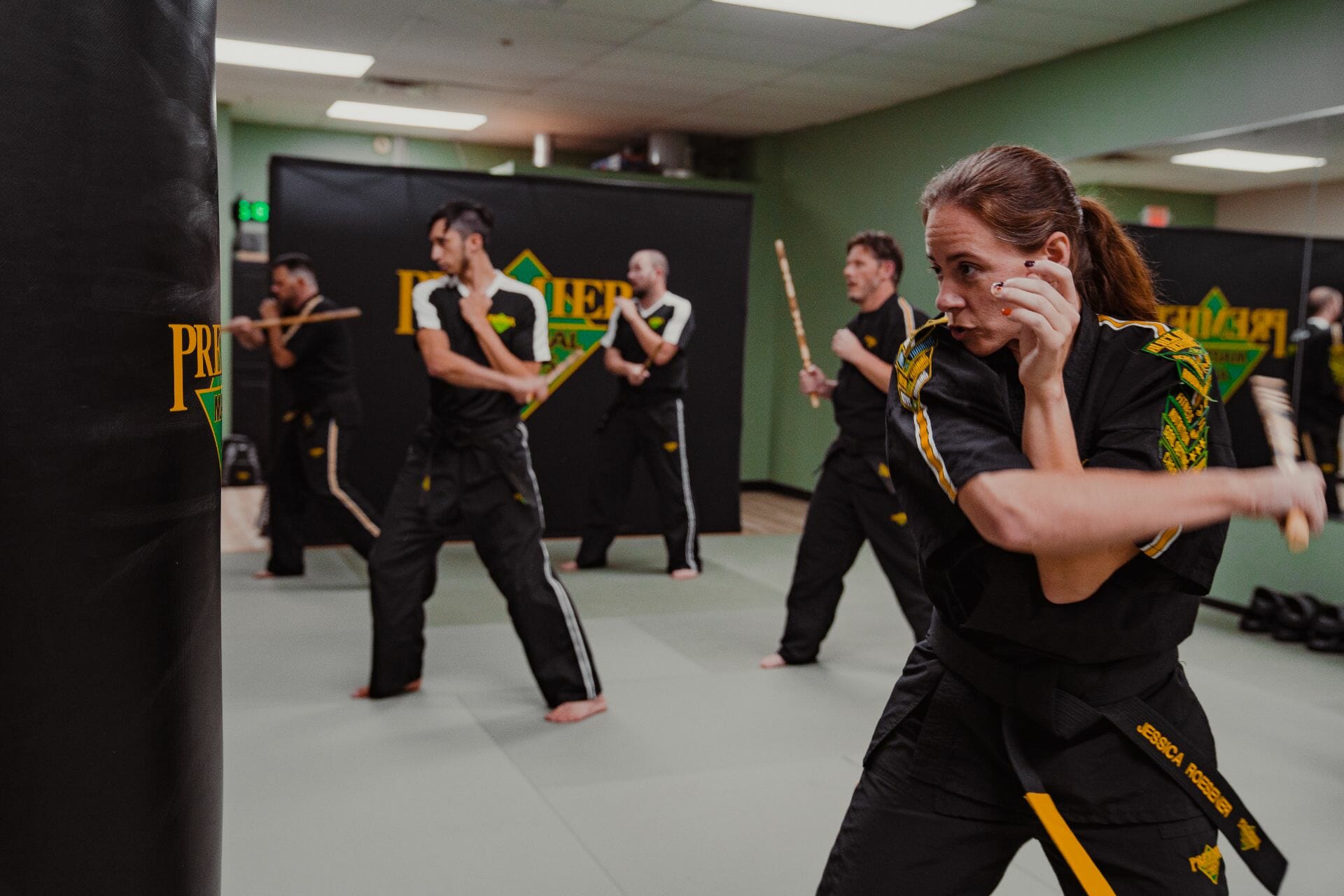 Adults practice their technique at a Premier Martial Arts Studio