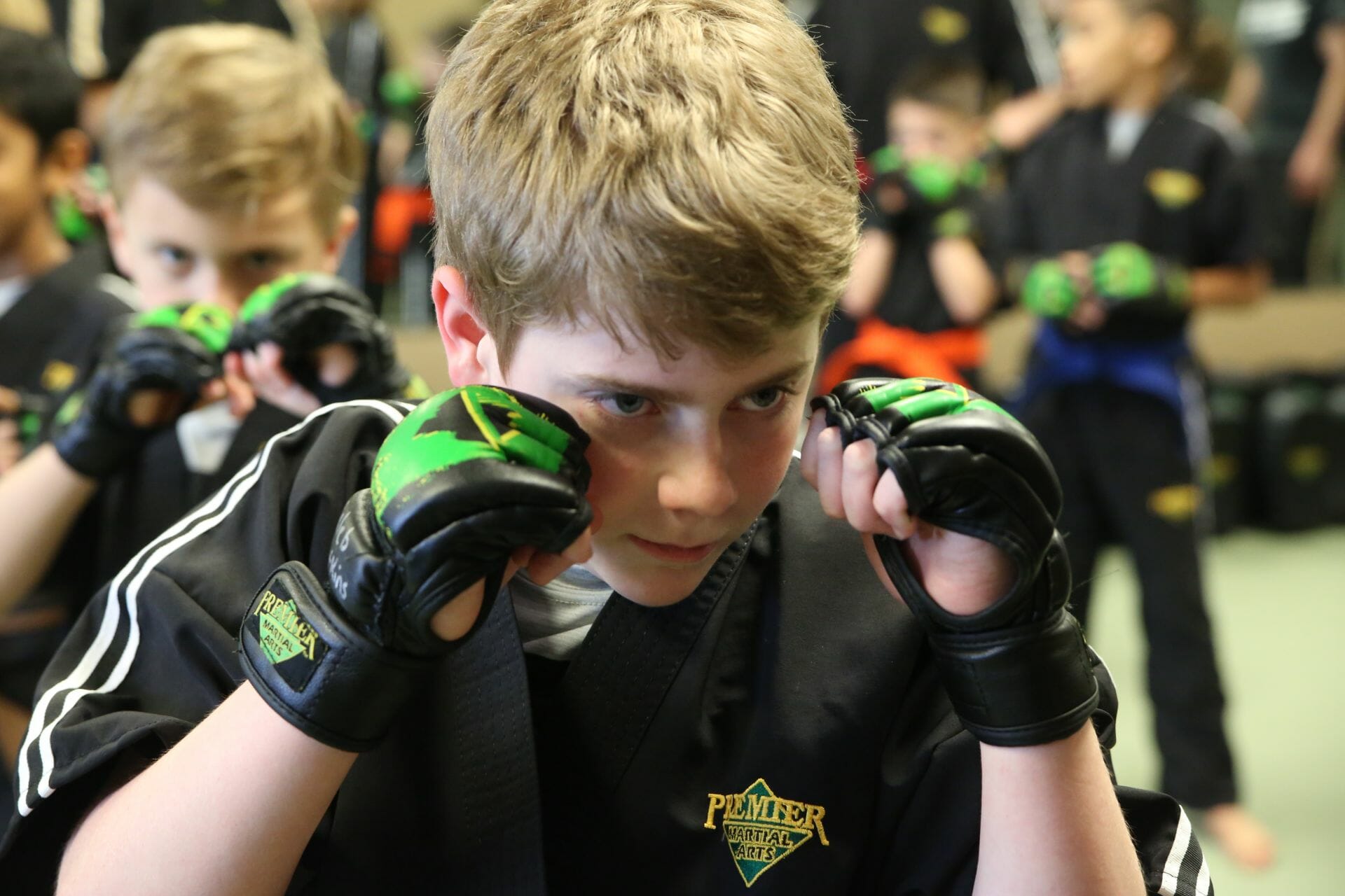 A boy with a determined looks practices at Premier Martial Arts